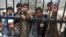 FILE: Stranded travllers wait to cross into Pakistan from Afghanistan at the Torkham border in March.