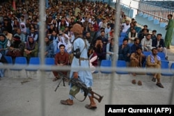 A Taliban fighter watches over spectators of a Twenty20 cricket match between two Afghan teams in Kabul in September.