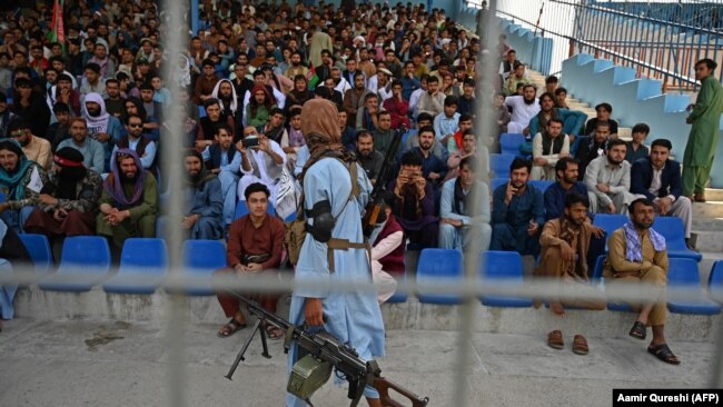 Një luftëtar taliban duke vëzhguar spektatorët në një ndeshje kriketi në Kabul. Shtator, 2021.