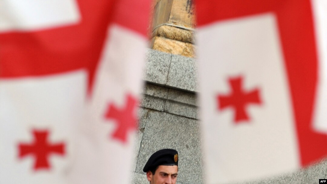 A Georgian policeman watches a mid-May opposition rally from near the parliament building.