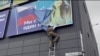 Ukraynalı hərbçi Vovçanskda plakatı cırır, 13 sentyabr, 2022-ci il