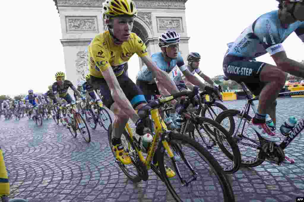 The winner of the 2013 Tour de France, Briton Christopher Froome (in yellow), rides with the pack past the Arc de Triomphe in Paris near the end of the race&#39;s final stage. (AFP/Fred Dufour)