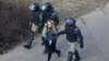 A woman is led away by Belarusian police after they broke up a rally in Minsk on March 27.