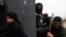 A member of the Al-Nusra Front, with an Al-Qaeda flag on his jacket (center), holds a position with fellow members of the militant group on the outskirts of Aleppo, Syria. (file photo)