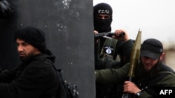 Pripadnik Al-Nusra Fronta, sa zastavom Al-Kaide na jakni (u sredini), drži položaj s ostalim članovima militantne grupe na periferiji Alepa, Sirija. (arhivska fotografija)