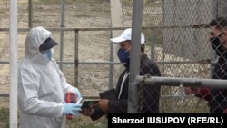 Сотрудник в защитном костюме на границе с Узбекистаном. Иллюстративное фото. 