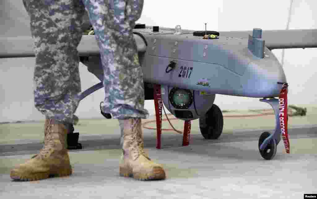 Soldat american în faţa unei drone, în timpul prezentării oficiale a noului sistem americano-german de avioane fără pilot "Shadow", la baza militară Vilseck-Grafenwoehr din Statele Unite.