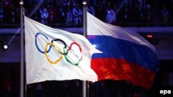 Олимпийский флаг рядом со флагом России на открытии зимней Олимпиады в Сочи в 2014 году. Иллюстративное фото.
