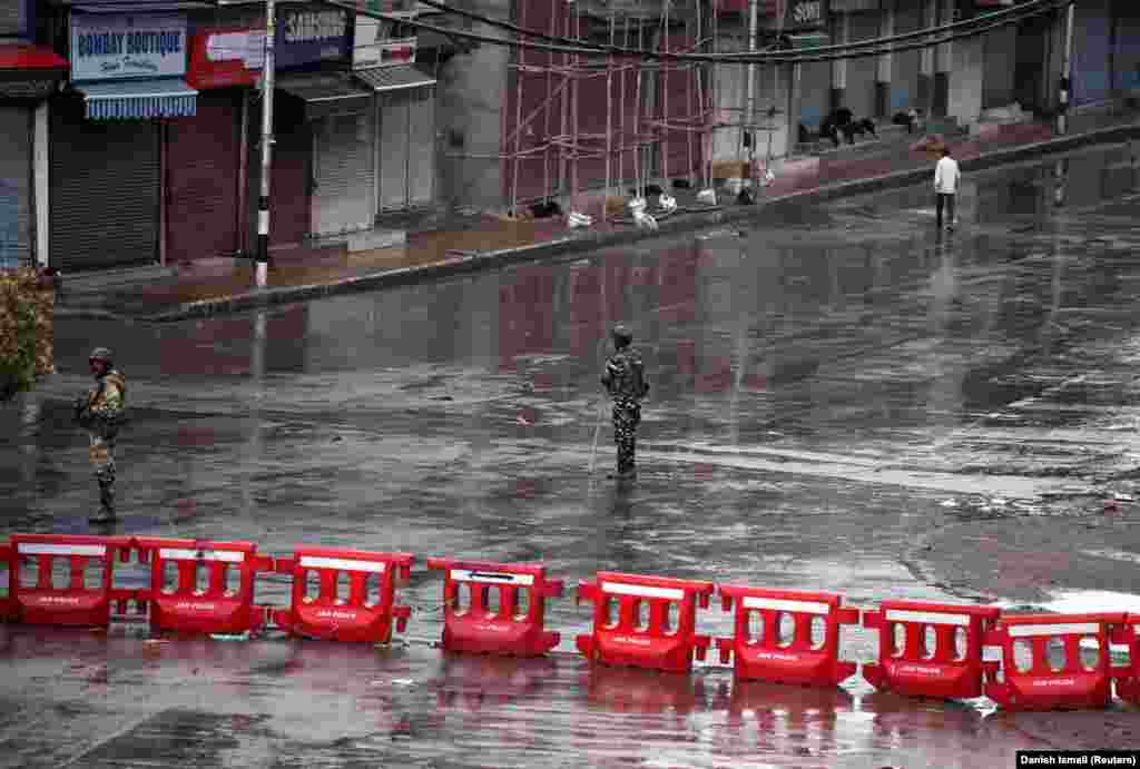 Indian security force personnel stand guard in a deserted street during restrictions after the government scrapped special status for Kashmir, in Srinagar on August 8.