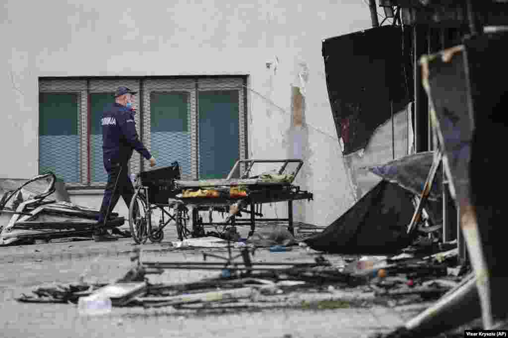 Policajac prolazi pored ostataka privremene COVID bolnice u Tetovu, Severna Makedonija, gde je 9. septembra u požaru nastradalo 14 osoba