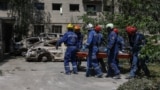 Rescue workers in Kyiv remove a body from a building hit in a massive Russian drone and missile attack on the Ukrainian capital. 