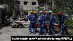 Rescue workers in Kyiv remove a body from a building hit in a massive Russian drone and missile attack on the Ukrainian capital. 