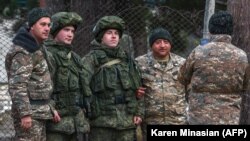 NAGORNO-KARABAKH -- Armenian servicemen pose for a picture with Russian peacekeepers as they leave a region outside the town of Kalbajar, November 23, 2020