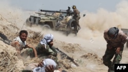 Iraqi pro-government forces fire an antitank cannon near the Al-Sejar village northeast of Fallujah on May 25.