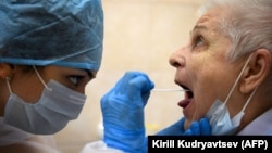 A medic takes a swab from a woman at a medical facility in Moscow to test for the coronavirus on July 16.