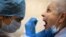 A medic takes a swab from a woman at a medical facility in Moscow to test for the coronavirus on July 16.