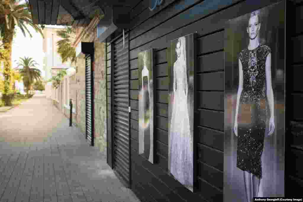 A shop advertises Western fashions, which few locals can afford.