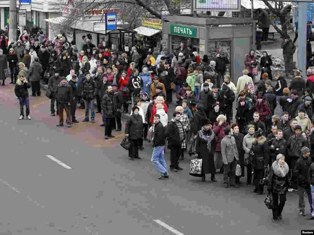 People wait for alternative public transport near Park Kultury after train services were disrupted.