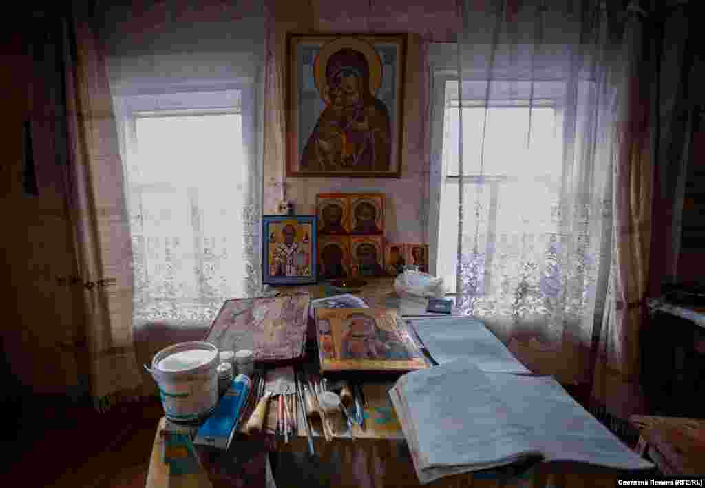 Рядом с готовыми работами на столе &ndash; книги с правилами иконописного мастерства