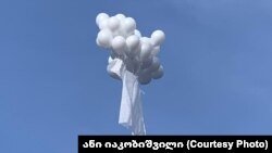 Родные Важи Гаприндашвили запустили в небо белые шары, которые подняли за собой в воздух белый халат как символ того, что для врачей не существует границ