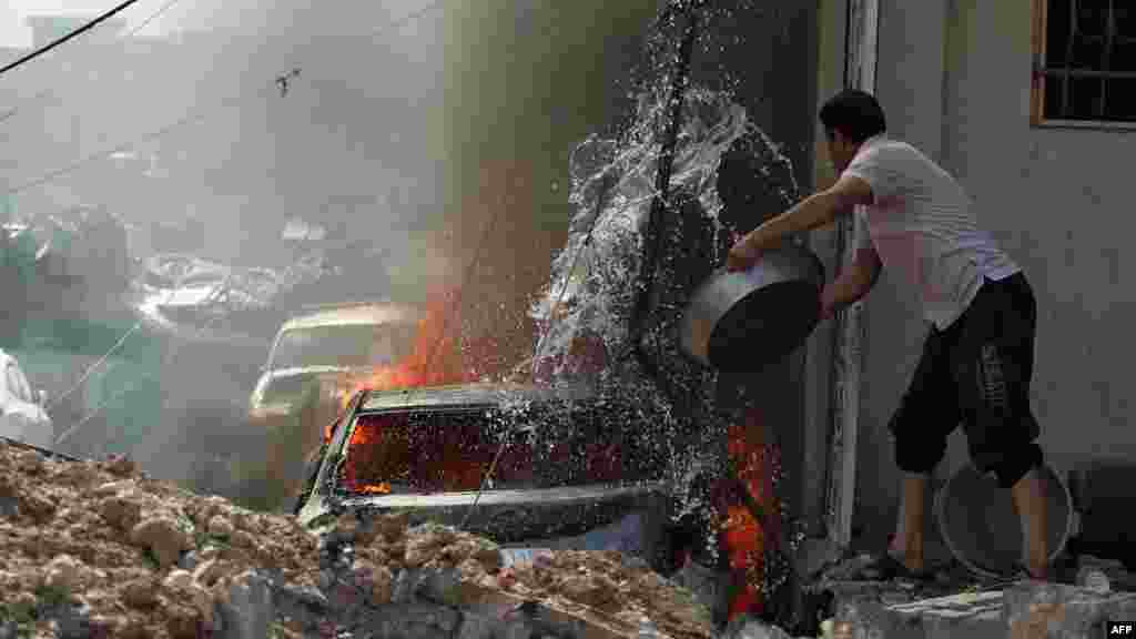 &nbsp;Yragyň terrora garşy gulluklarynyň YD jeňçilerine garşy dowam edýän söweşlerinde Mosulyň günbatar Rifai mähellesine ilerleýän wagtynda ýanýan maşynyň oduny öçürmäge synanýan yrakly. 16-njy maý (AFP/Ahmad al-Rubaye)