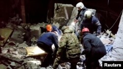 Echipele de intervenție recuperează corpul unei persoane de sub dărâmăturile unei clădiri devastate în urma unui atac ucrainean asupra orașului ocupat Lisiceansk, 3 februarie 2024.