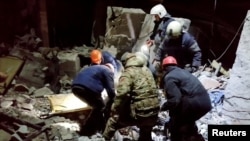 Emergency workers retrieve bodies from the rubble of a building following a missile strike in Lysychansk on February 3.