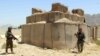 Afghan soldiers inspect the scene after overnight clashes with Taliban militants at a military base in Kandahar Province on July 26.