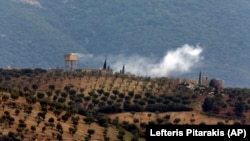 Smoke billows from a position inside Syria after Turkish Army shelling, as seen from the outskirts of the village of Sugedigi, Turkey, adjacent to the border with Syria, on January 21.