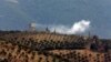 Smoke billows from a position inside Syria after Turkish Army shelling, as seen from the outskirts of the village of Sugedigi, Turkey, adjacent to the border with Syria, on January 21.