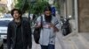 A man uses his cell phone while walking on a sidewalk in downtown Tehran, Iran, Wednesday, April 18, 2018 (AP Photo/Vahid Salemi)