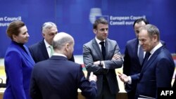Președintele francez Emmanuel Macron (centru), vorbind cu alți lideri ai UE înainte de summitul lor din 21 martie, la Bruxelles 