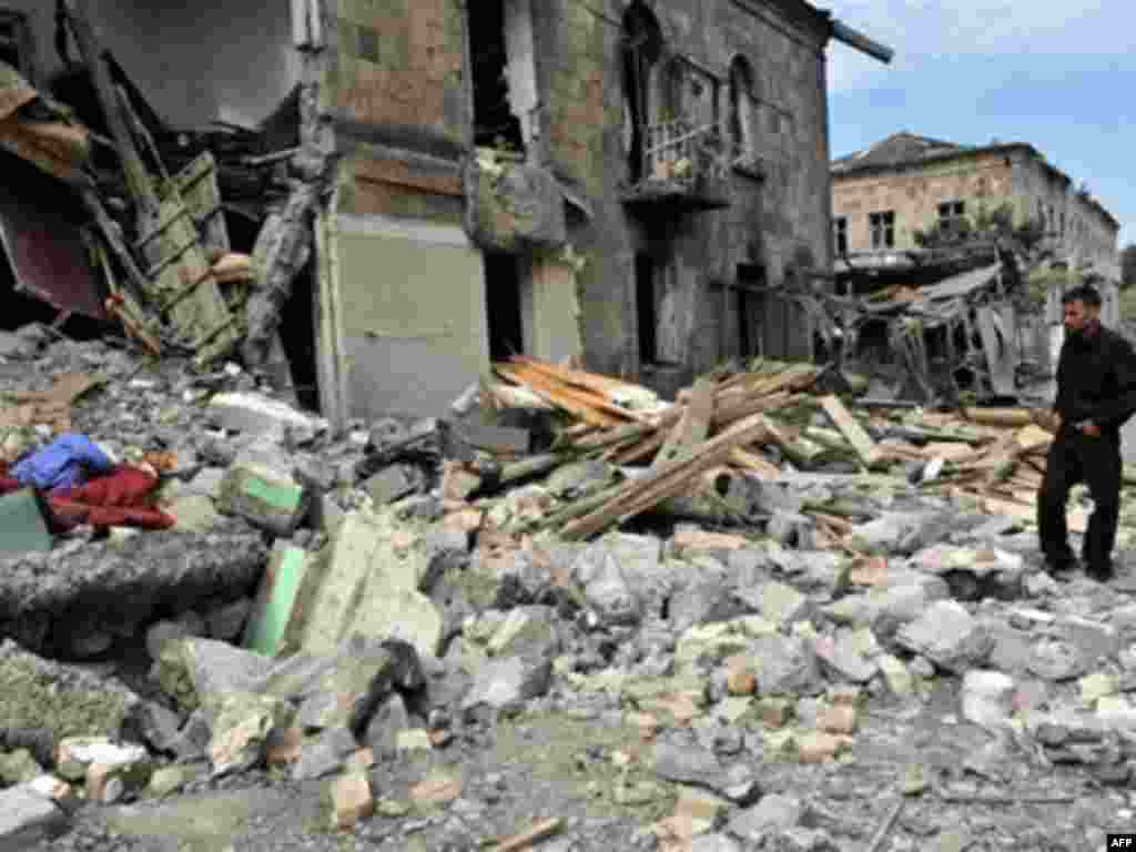 Зруйнований житловий комплекс в Ґорі, 11 серпня, 2008 - GEORGIA, GORI : A Georgian man stands among ruins in front of his damaged home in Gori on August 11, 2008. The conflict has already forced about 40,000 people from their homes in areas around the conflict zone, a