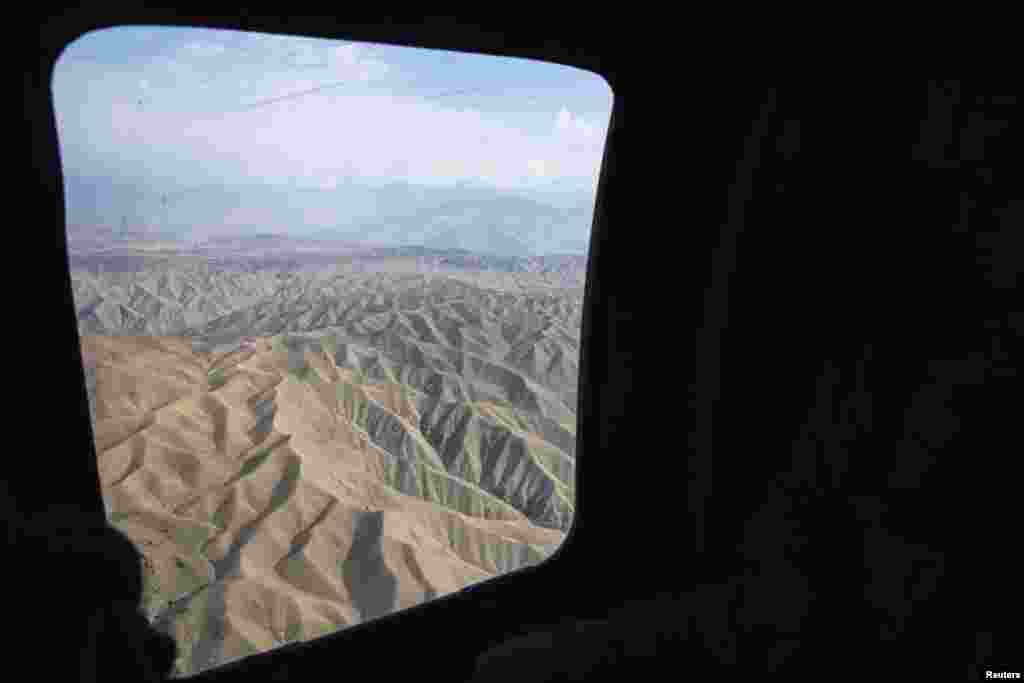The mountainous terrain of eastern Afghanistan is seen through the window of a UH-60 Blackhawk helicopter near Bagram Air Field in Parwan Province. (Reuters/Lucas Jackson)