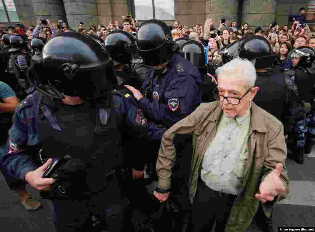 An elderly man being detained by police. The man later apparently collapsed.