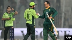 د جنوبي افریقا کوېنټن ډي کاک د سیالۍ تر ګټلو وروسته د پاکستان محمد رضوان ته لاس ورکوي - د نومبر شپږمې انځور. 