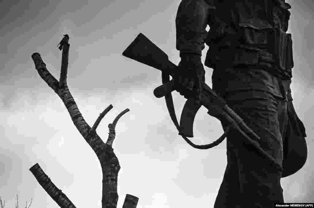 A bird sits on a tree next to a monument in Moscow to Soviet soldiers killed in Afghanistan. (AFP/Aleksandr Nemenov)