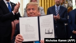 U.S. President Donald Trump shows his signature on Space Policy Directive-4 at the White House in February, which directed the Defense Department to establish the Space Force.