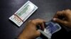 A currency trader counts Pakistani rupee notes as he prepares an exchange of U.S dollars in Islamabad.