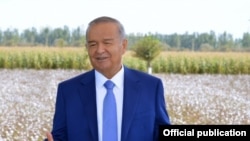 Uzbek President Islam Karimov stands in front of his country's biggest export.