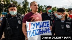 Московската полиция задържа участник в демонстрация, който носи плакат с надпис "Умно гласуване", 14 август 2021 г.