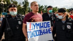 Московската полиция задържа участник в демонстрация, който носи плакат с надпис "Умно гласуване", 14 август 2021 г.
