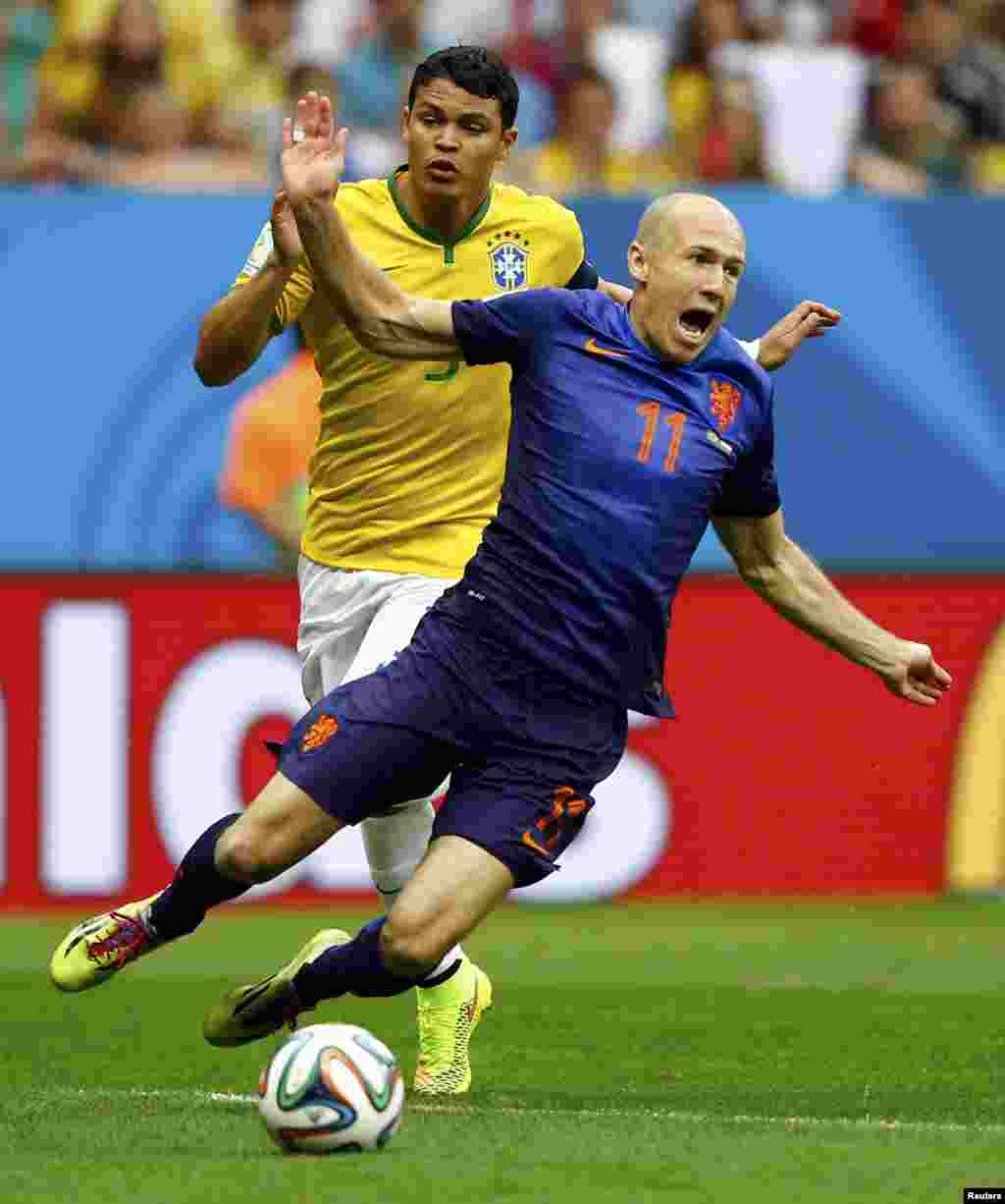 Brazil. 12Jul. Brazil's Thiago Silva (L) fouls Arjen Robben of the Netherlands to concede a penalty during their 2014 World Cup third-place playoff at the Brasilia national stadium in Brasilia