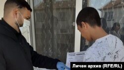 Медиаторът Бойчо Кочев раздава на учениците материали и им обяснява как да ги попълнят