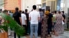 Adamlar pul çekmek üçin bankomatyň daşyndaky nobatda dur. Türkmenistan (arhiw suraty).