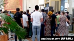 Adamlar pul çekmek üçin bankomatyň daşyndaky nobatda dur. Türkmenistan (arhiw suraty).