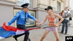 Путинге қарсы акцияға шыққан Femen ұйымының мүшесін полиция ұстап тұр. Киев, 18 шілде 2013 жыл