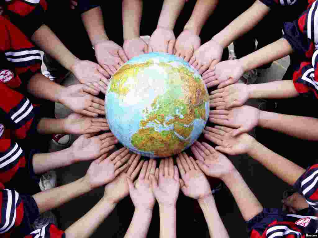 Students pose for a photo with a globe during a campaign to mark World Earth Day in a middle school in Dexing, China on April 19. World Earth Day falls on April 22 every year. Photo by China Daily/Reuters 