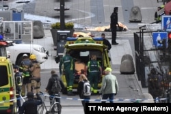 Emergency services work at the scene where a truck crashed into a department store in central Stockholm on April 7, 2017.