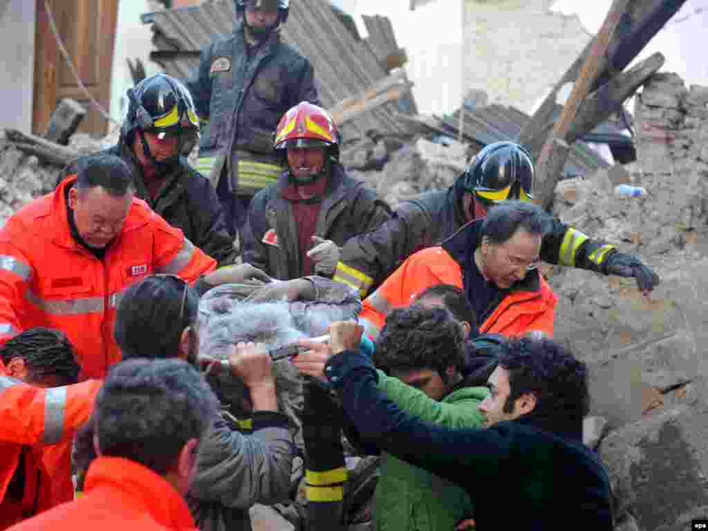 Italy - Italian rescue teams retrieve a person from a building which collapsed following an earthquake, in L'aquila, 06Apr2009 - Caption: epa01689457 Italian rescue teams retrieve a person from a building which collapsed following an earthquake, in L'aquila, Central Italy, 06 April 2009. At least nine people were killed 06 April in the central Italian region of Abruzzo when a magnitude-5.8 earthquake struck, police said. Five of the dead were from Castelnuovo, where dozens of houses and a church collapsed, they said in their initial toll from the disaster, which did not include four children that Italian media reported had died in a hospital in LAquila, Abruzzo's capital. Numerous buildings collapsed in LAquila, where people were searching for survivors in the rubble of a house and student dormitory in the citys historic centre. EPA/PERI - PERCOSSI 